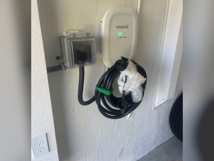 Electrician installing a Level 2 EV charger in a Miami home