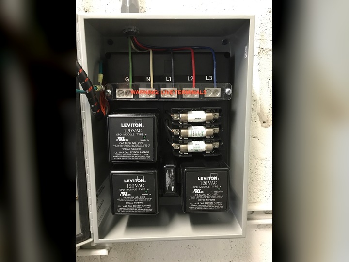 Whole-home surge protector device installed in an electrical panel
