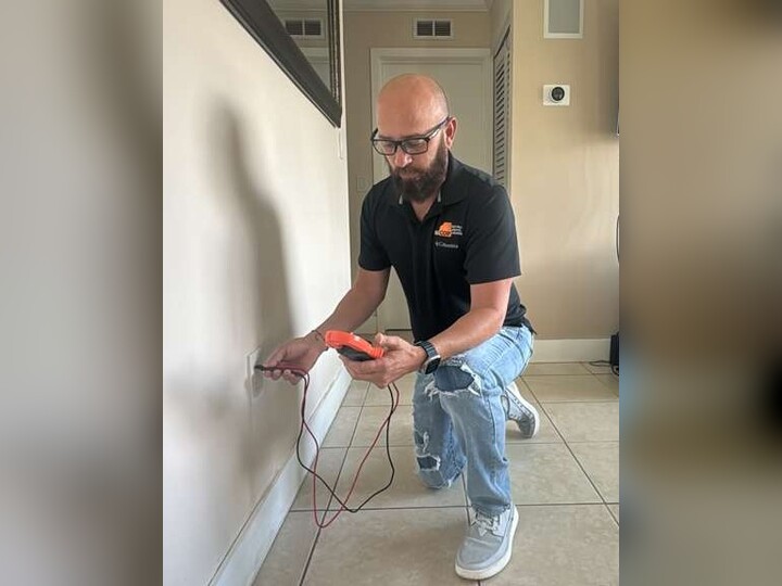 Electrician performing a home electrical safety inspection in Miami